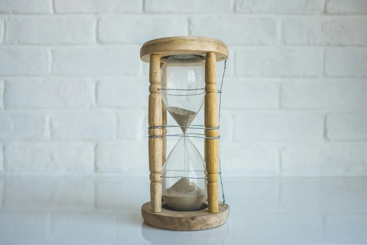 Eine Sanduhr vor einer weißen Wand